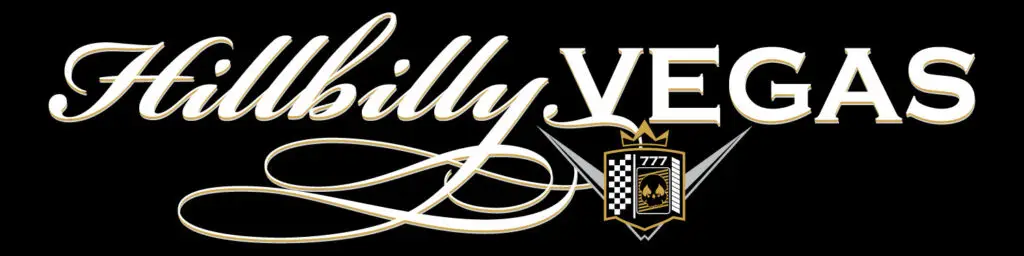 Logo for Hillbilly VEGAS: gold cursive text on black with decorative swirls and a crest featuring a skull, checkerboard pattern, and 777.